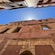 The upper facade of a crumbling building with open windows framed by narrow alley walls